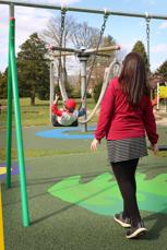 Amanda with James on a swing in the park