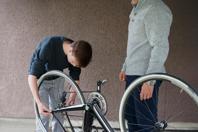 Andrew being supervised changing a cycle wheel